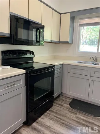 a kitchen with cabinets appliances and a window