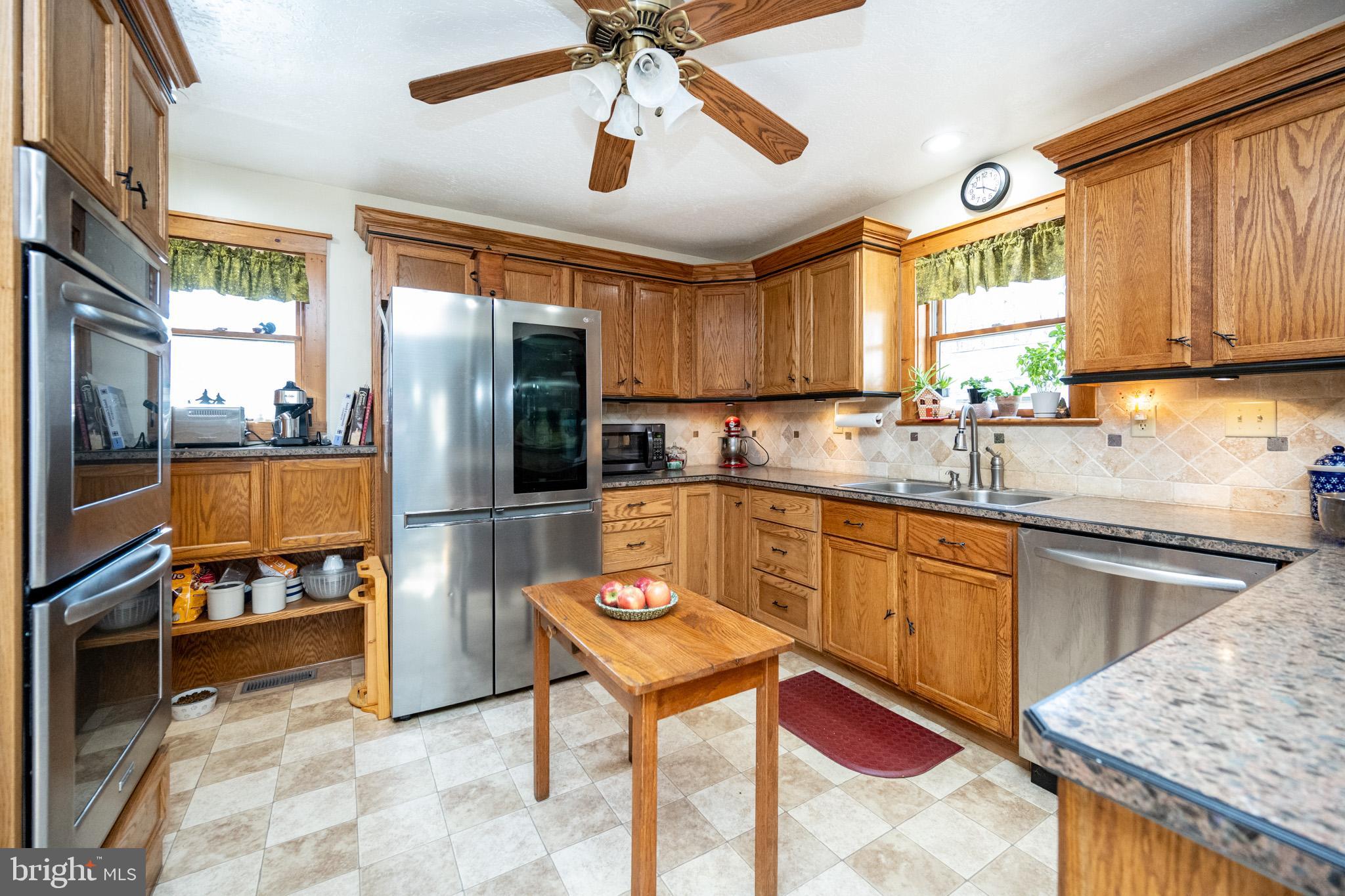 328 Stool Rock Road Oakland, MD 21550 - Photo 22 of 117 a kitchen with stainless steel appliances granite countertop a refrigerator a sink a stove and island