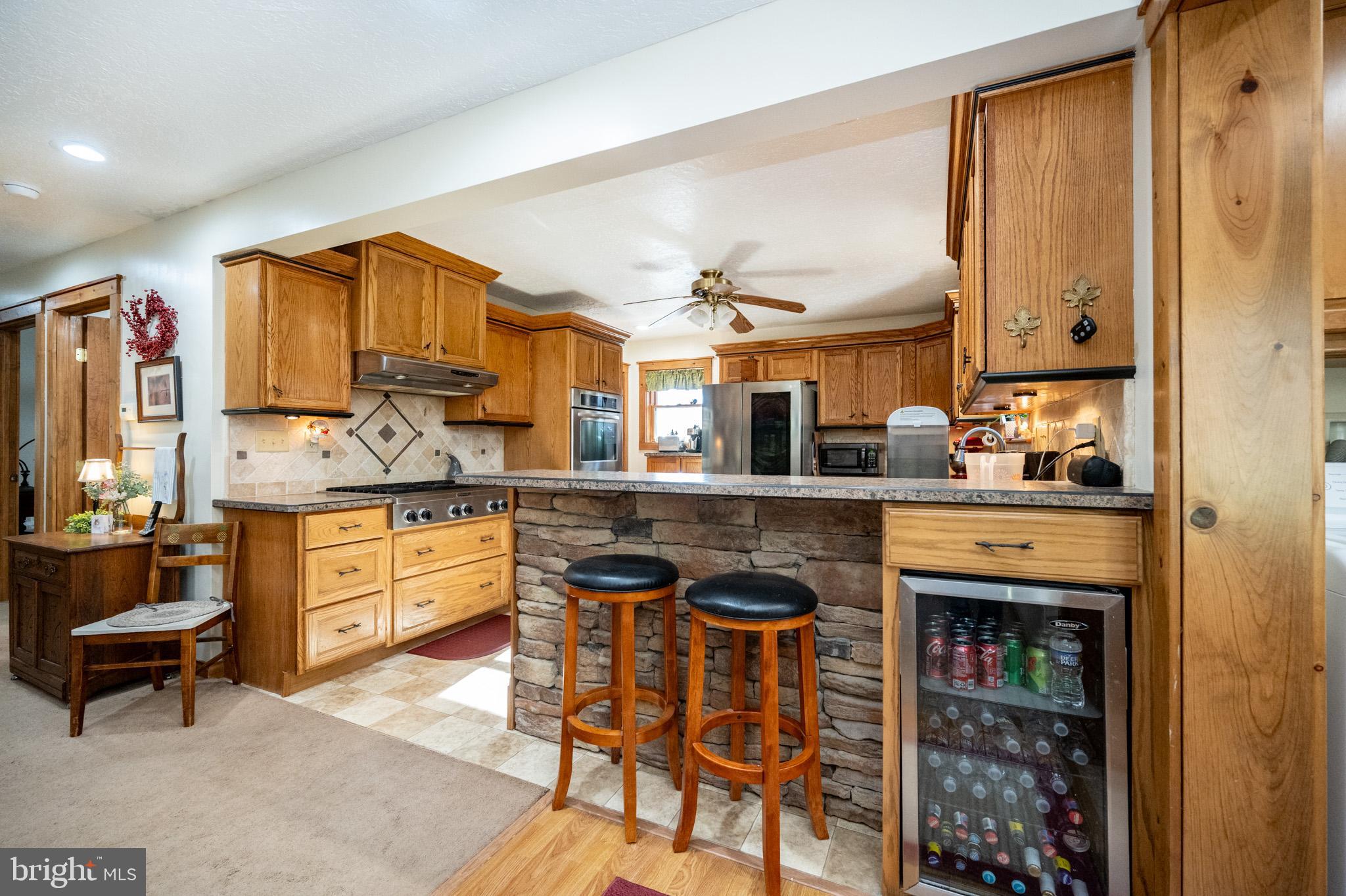 328 Stool Rock Road Oakland, MD 21550 - Photo 28 of 117 a kitchen with stainless steel appliances granite countertop a stove and a refrigerator