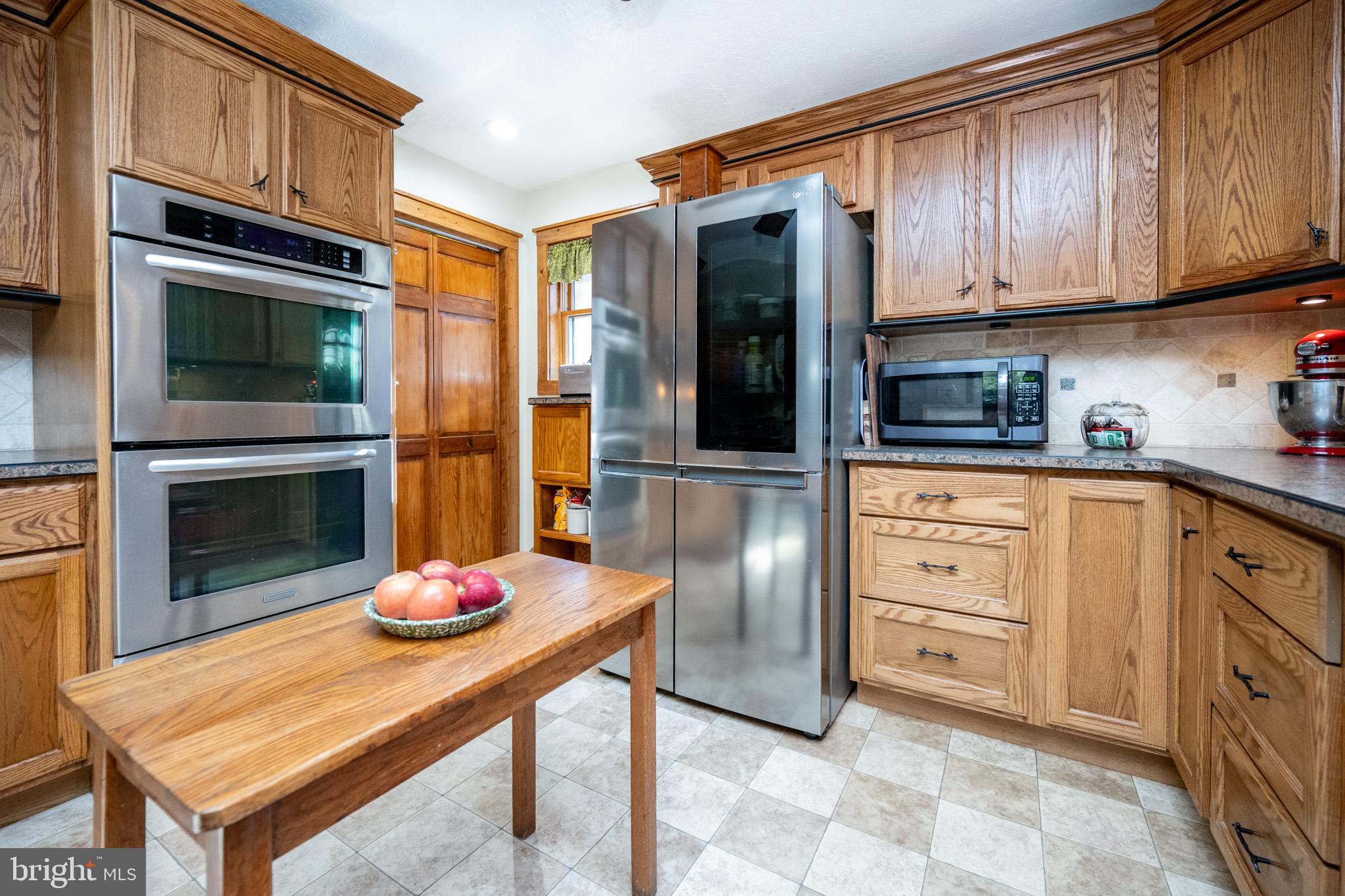 328 Stool Rock Road Oakland, MD 21550 - Photo 30 of 123 a kitchen with stainless steel appliances kitchen island granite countertop a table chairs in a microwave