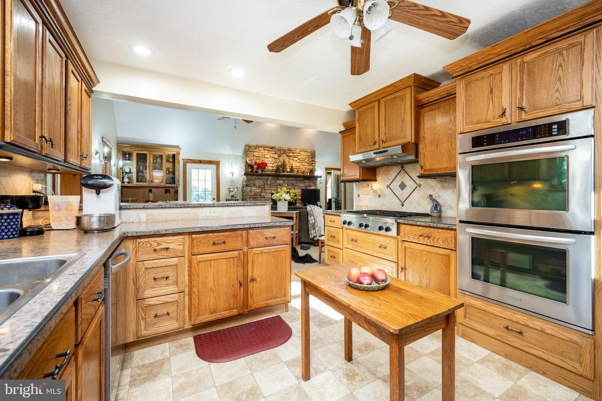 328 Stool Rock Road Oakland, MD 21550 - Photo 32 of 123 a kitchen with stainless steel appliances granite countertop a stove top oven a sink dishwasher and cabinets with wooden floor
