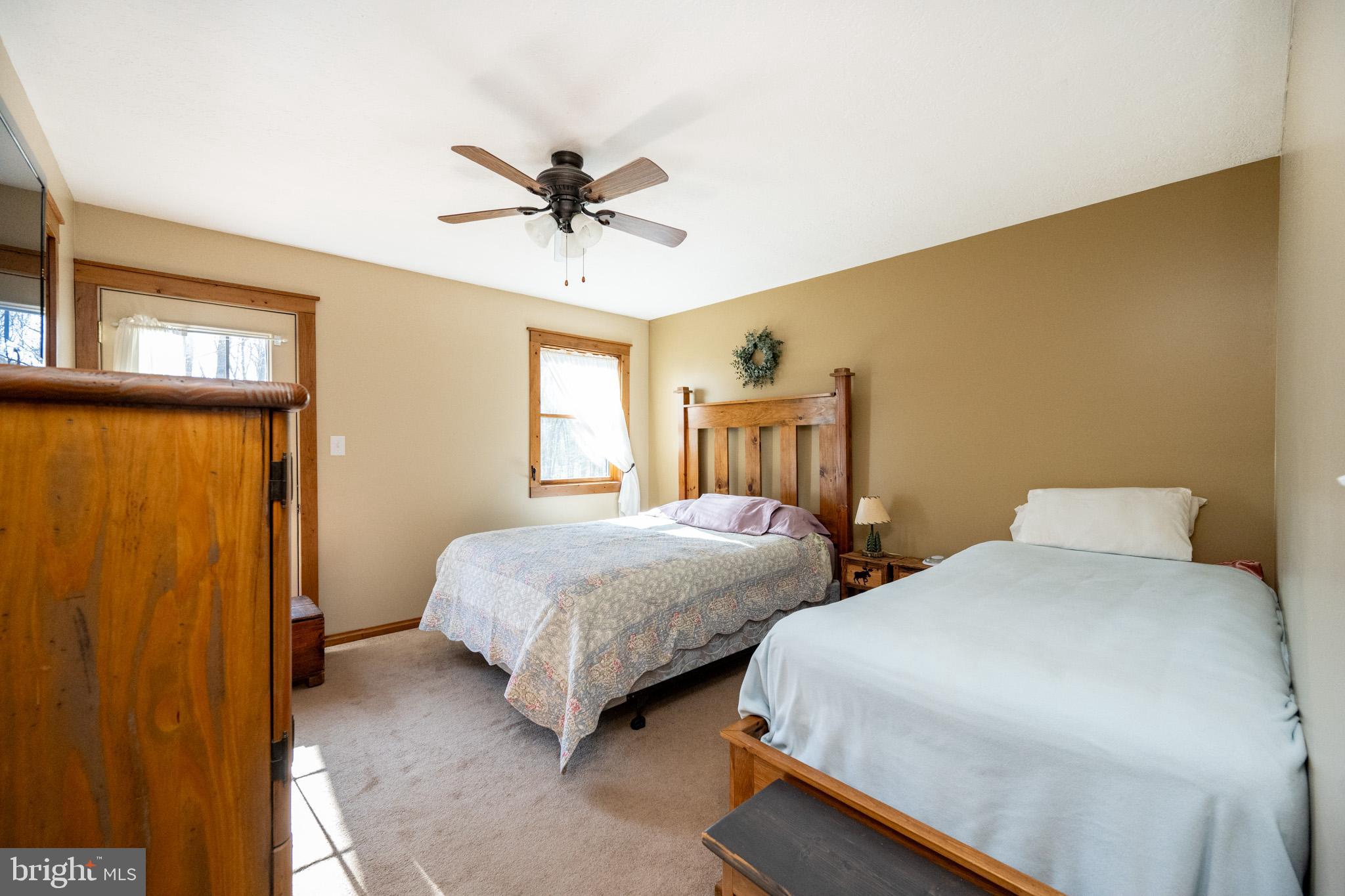 328 Stool Rock Road Oakland, MD 21550 - Photo 64 of 117 a bedroom with two beds a chandelier and a window