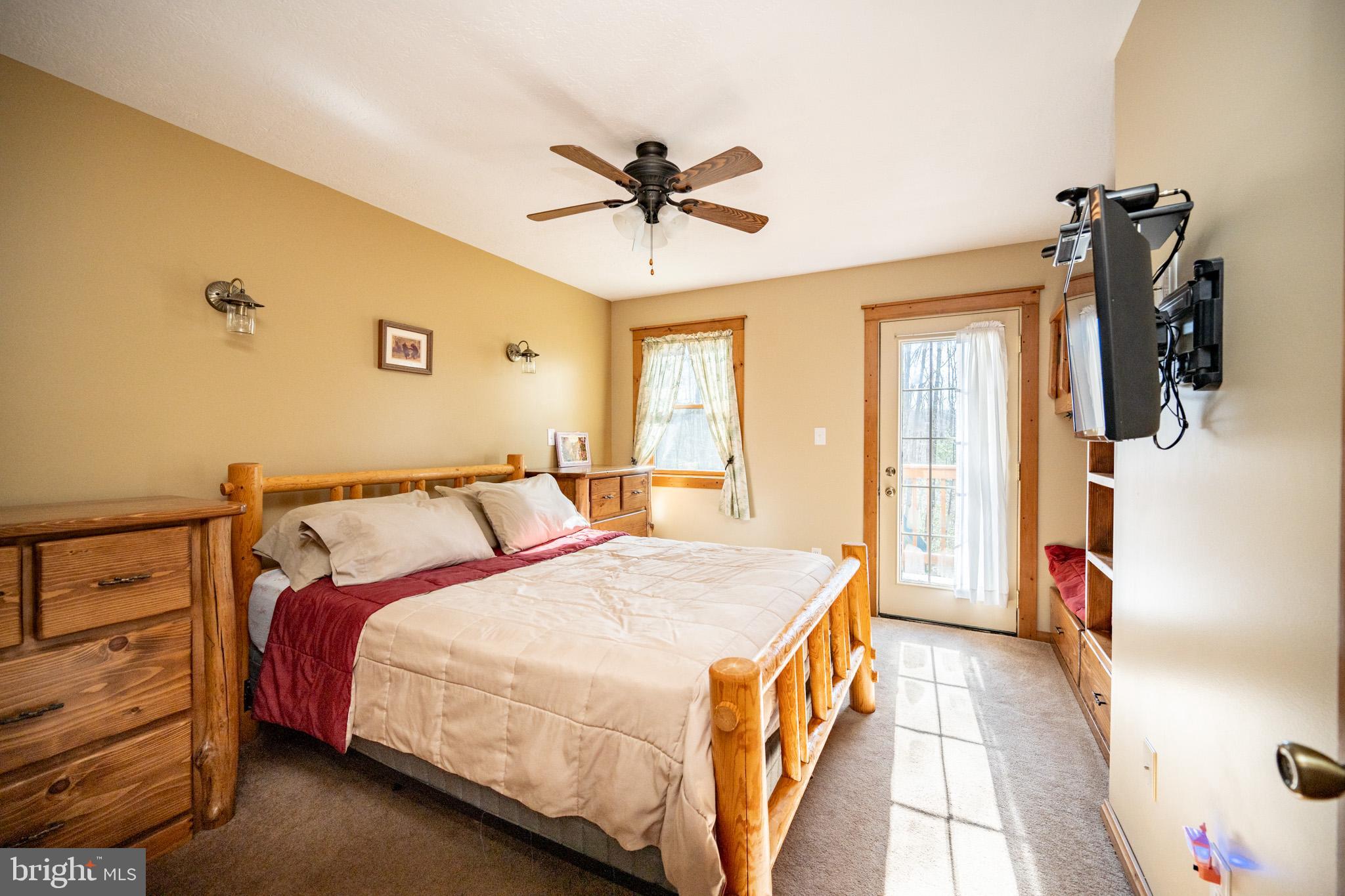 328 Stool Rock Road Oakland, MD 21550 - Photo 73 of 123 a spacious bedroom with a bed and a chandelier