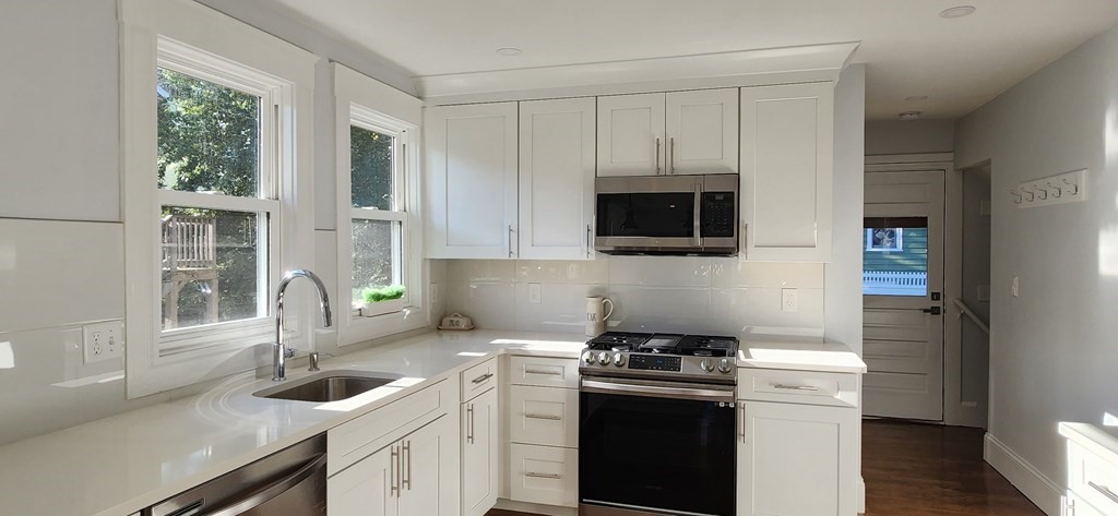 38 Kimball Road, Unit 2 Watertown, MA 02472 - Photo 8 of 29 a kitchen with stainless steel appliances granite countertop a sink stove and microwave