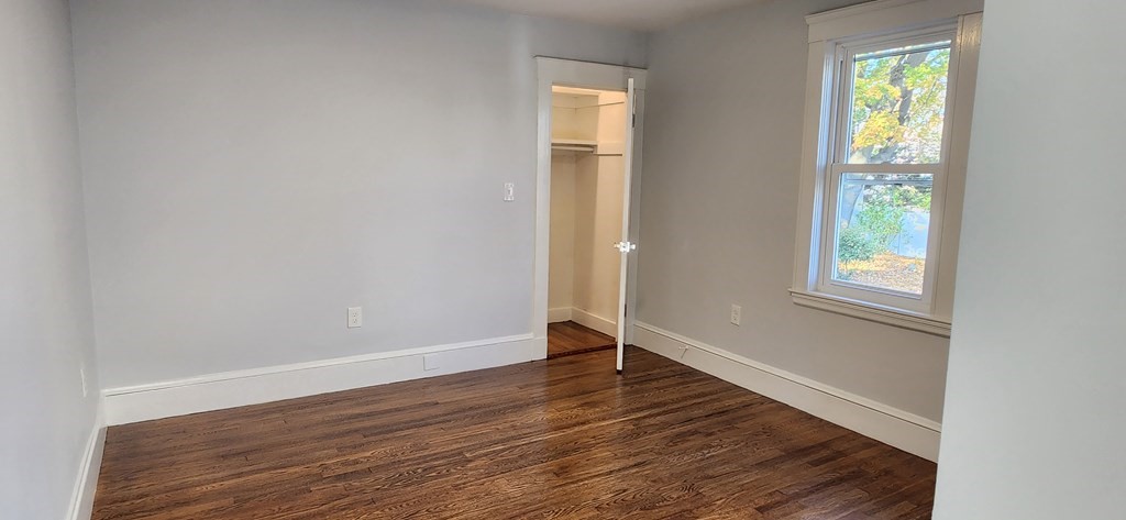 38 Kimball Road, Unit 2 Watertown, MA 02472 - Photo 9 of 29 an empty room with wooden floor and windows