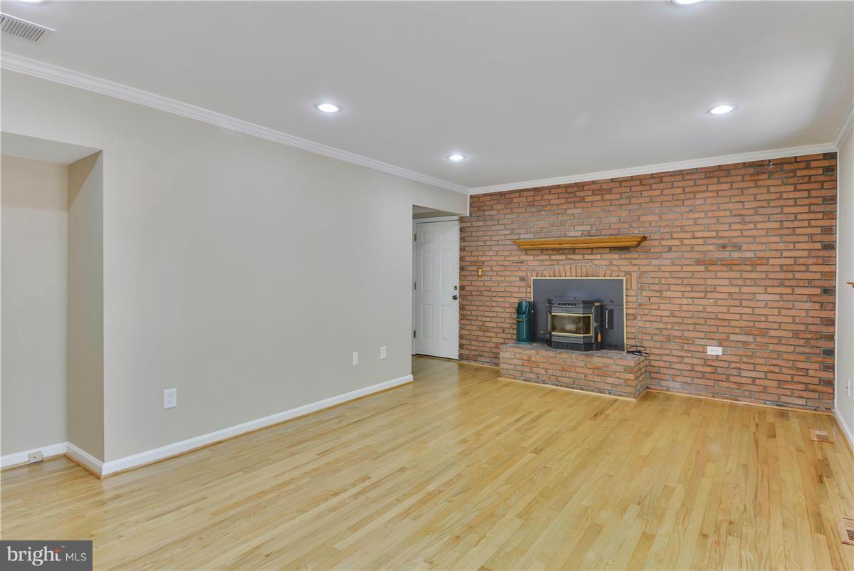 15212 Philip Lee Road Chantilly, VA 20151 - Photo 14 of 30 a view of empty room with wooden floor and fireplace