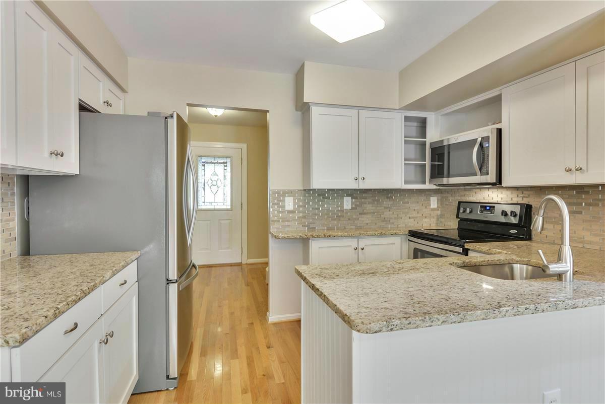 15212 Philip Lee Road Chantilly, VA 20151 - Photo 5 of 30 a kitchen with stainless steel appliances granite countertop a sink stove and cabinets