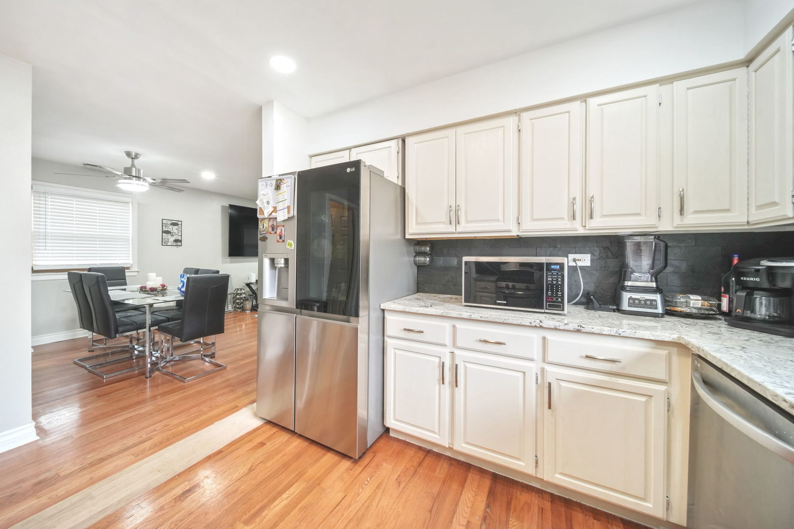 7235 Park Avenue Summit, IL 60501 - Photo 12 of 30 a kitchen with stainless steel appliances granite countertop a refrigerator a stove a sink and white cabinets with wooden floor