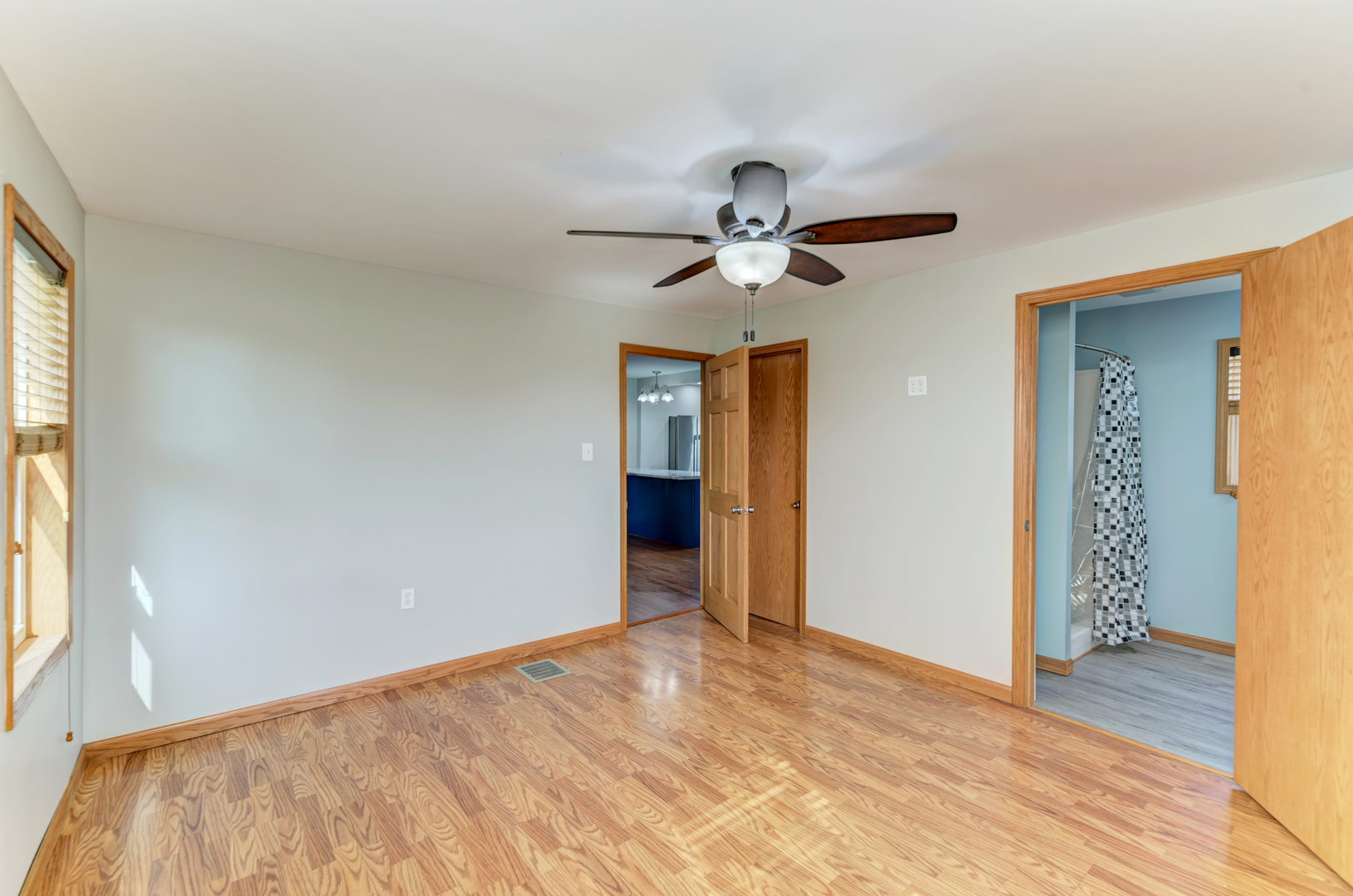 17357 Sedgewick Road Plano, IL 60545 - Photo 17 of 36 a view of a big room with wooden floor and a chandelier fan