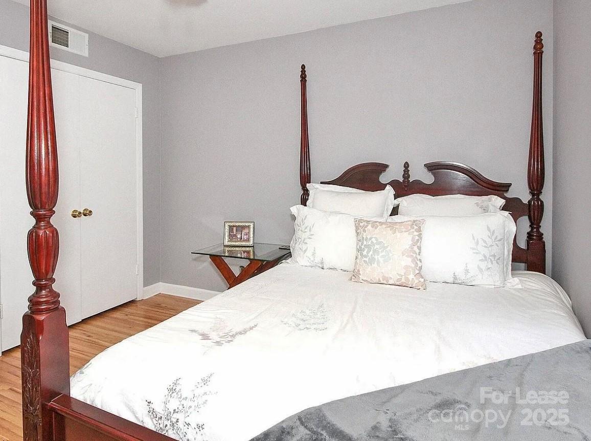 858 McAlway Road, Unit A Charlotte, NC 28211 - Photo 18 of 20 a bedroom with a bed and wooden floor