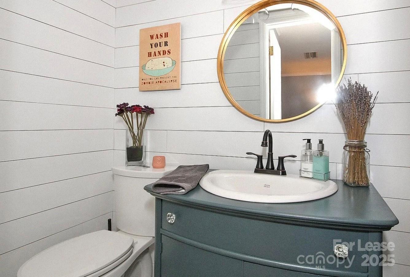 858 McAlway Road, Unit A Charlotte, NC 28211 - Photo 19 of 20 a bathroom with a toilet sink and mirror