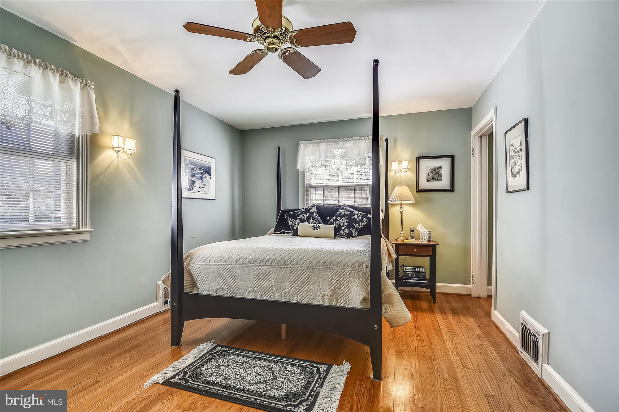 5209 Springlake Way Baltimore, MD 21212 - Photo 31 of 57 a bedroom with a bed a dresser and wooden floor