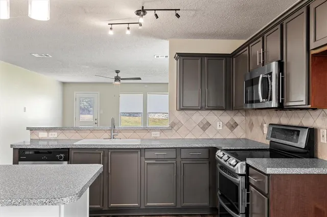 a kitchen with granite countertop a sink and stove