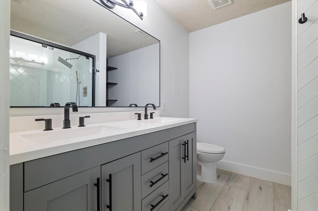 1448 Ridgecrest Drive Little Elm, TX 75068 - Photo 20 of 29 a bathroom with a sink a toilet and a mirror