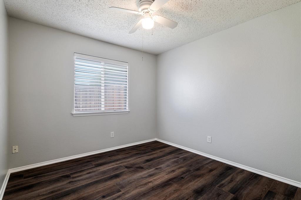 1448 Ridgecrest Drive Little Elm, TX 75068 - Photo 23 of 29 a view of an empty room with wooden floor and a window