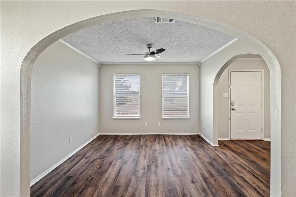 1448 Ridgecrest Drive Little Elm, TX 75068 - Photo 7 of 29 an empty room with wooden floor a ceiling fan and windows