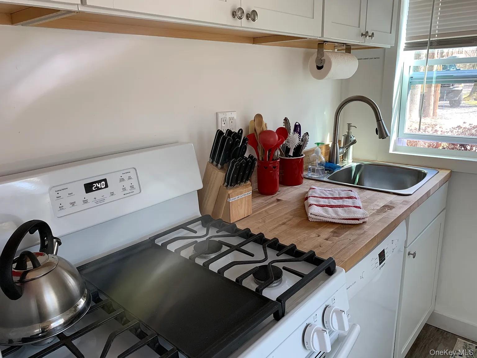 206 Sunset Cove Road Newburgh, NY 12550 - Photo 12 of 23 a kitchen with a stove and a sink with wooden floor