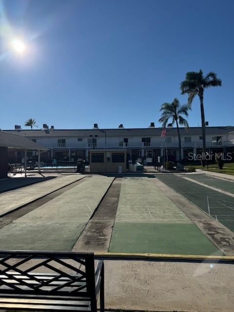 4746 Azalea Drive, Unit 103C New Port Richey, FL 34652 - Photo 32 of 35 a view of a swimming pool with a lawn chairs