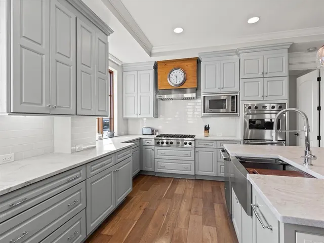 a kitchen with kitchen island granite countertop a sink cabinets and stainless steel appliances