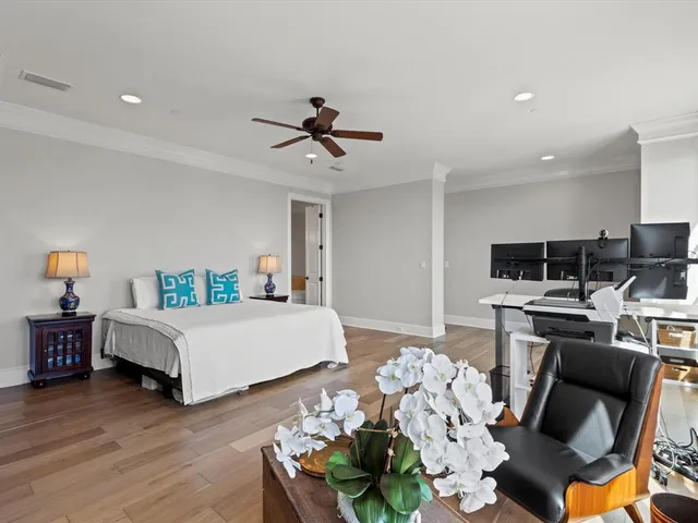 a bedroom with a bed a couch and a flat screen tv