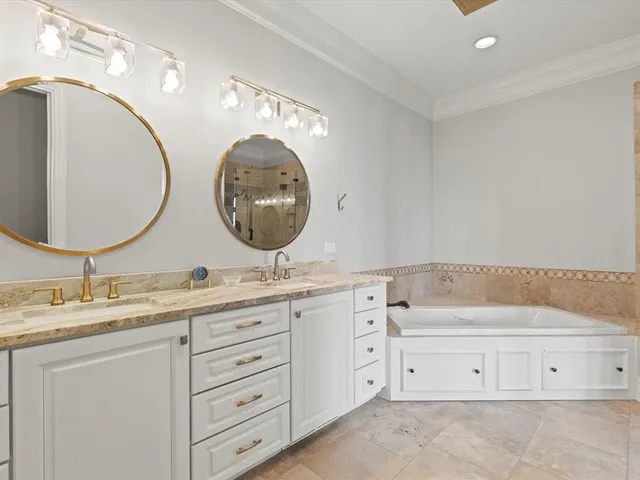 a bathroom with a granite countertop tub sink and mirror