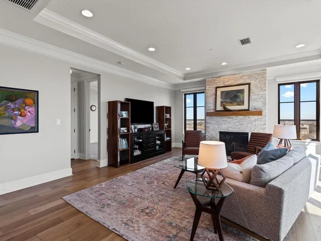 a living room with furniture a flat screen tv and a fireplace