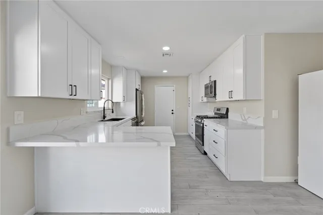 a kitchen with stainless steel appliances a refrigerator sink and cabinets