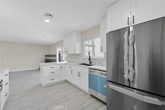 a kitchen with white cabinets and appliances