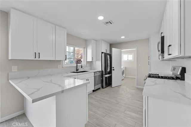 a large white kitchen with kitchen island a sink a stove and a refrigerator