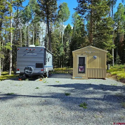 a view of a house with a yard and large tree