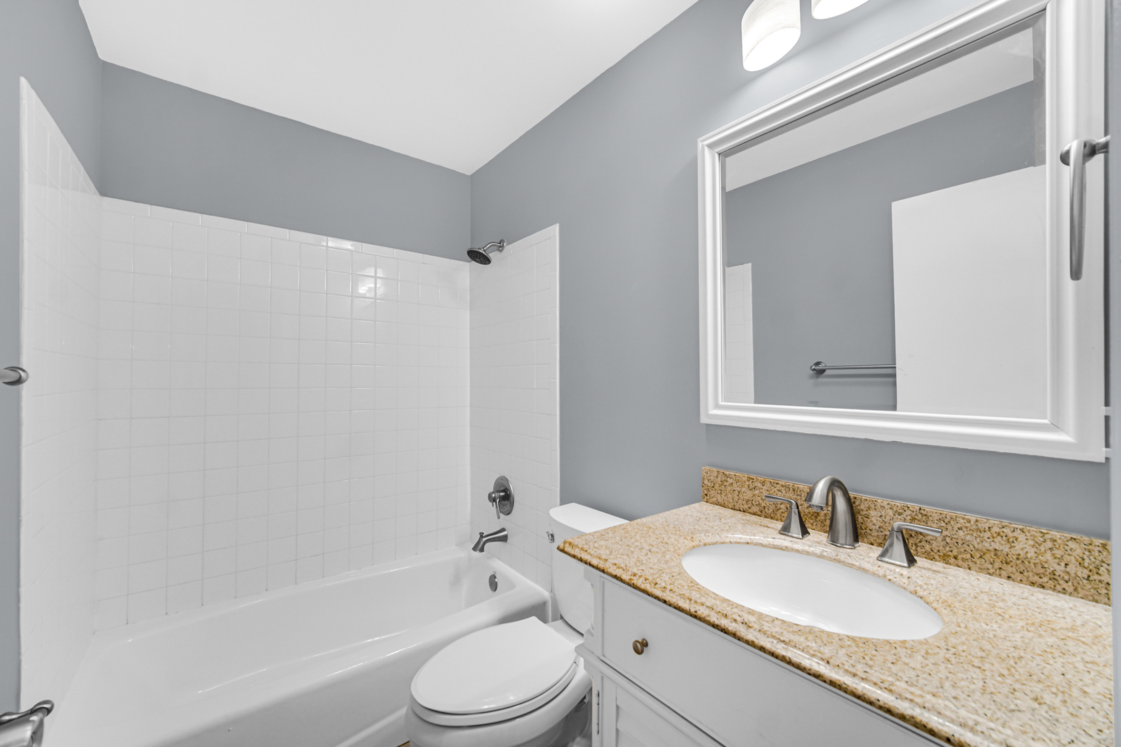 685 High Ridge Road, Unit 5762 Roselle, IL 60172 - Photo 8 of 25 a bathroom with a granite countertop sink a toilet a mirror and bathtub