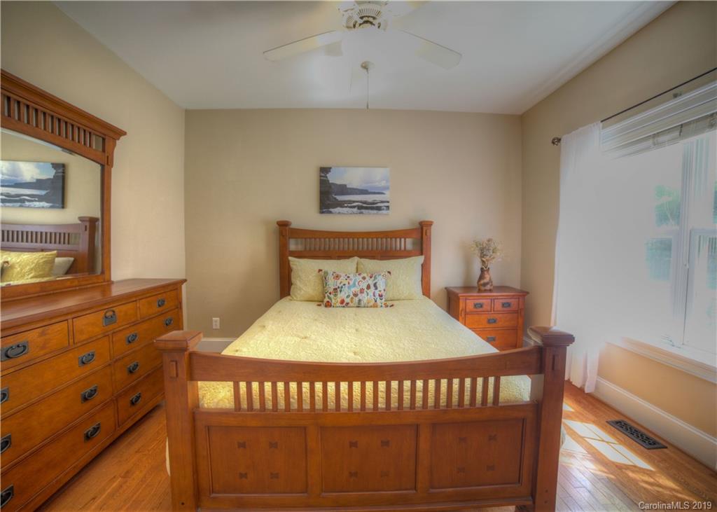 929 Ashford Way, Unit 79 Fort Mill, SC 29708 - Photo 14 of 39 a bedroom with a bed and wooden floor