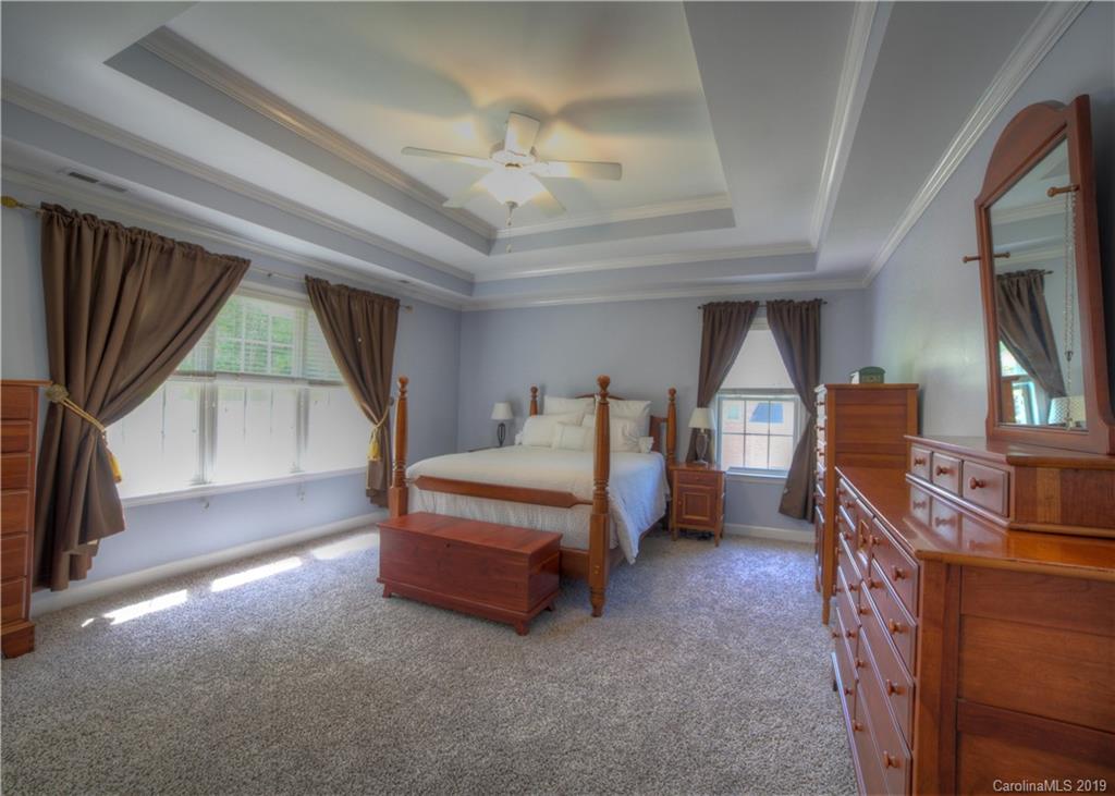 929 Ashford Way, Unit 79 Fort Mill, SC 29708 - Photo 19 of 39 a spacious bedroom with a bed and a chandelier
