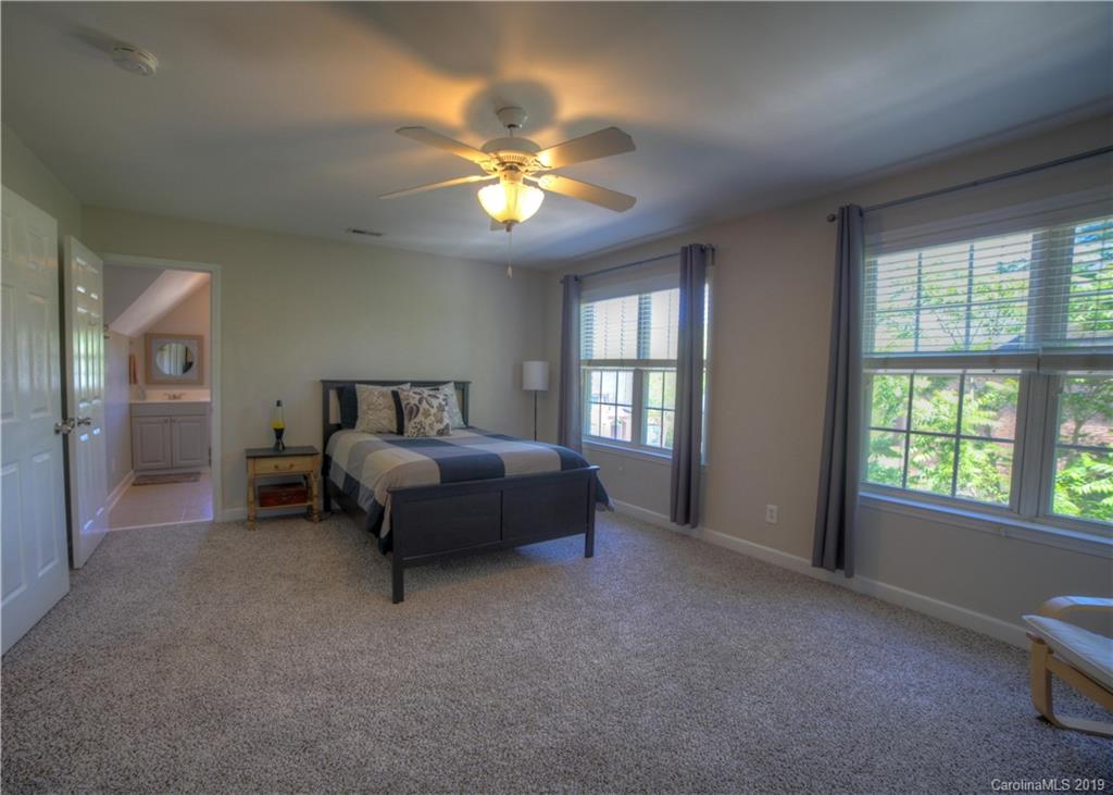 929 Ashford Way, Unit 79 Fort Mill, SC 29708 - Photo 26 of 39 a spacious bedroom with a bed and a chandelier