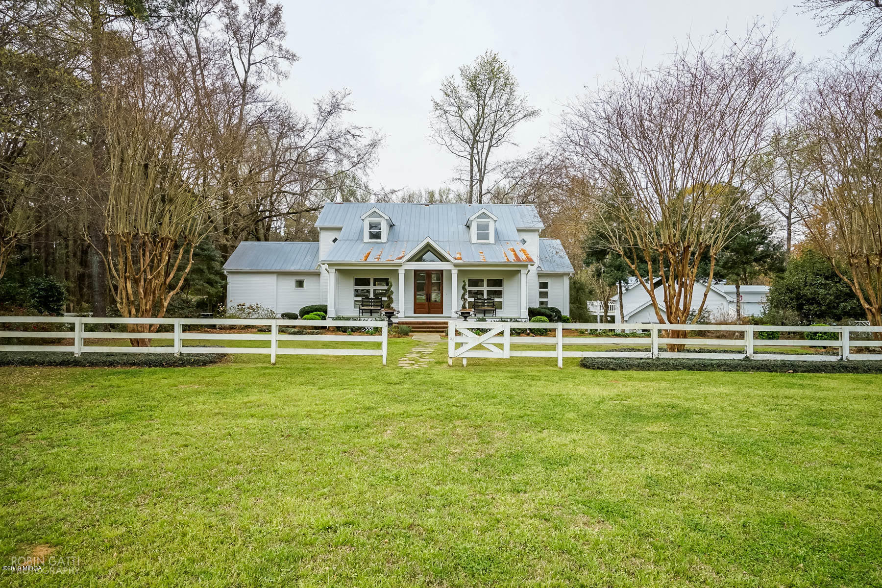 6150 Old Forsyth Road Macon, GA 31210 - Photo 1 of 50 a view of a white house with a large pool and a big yard with plants and large trees