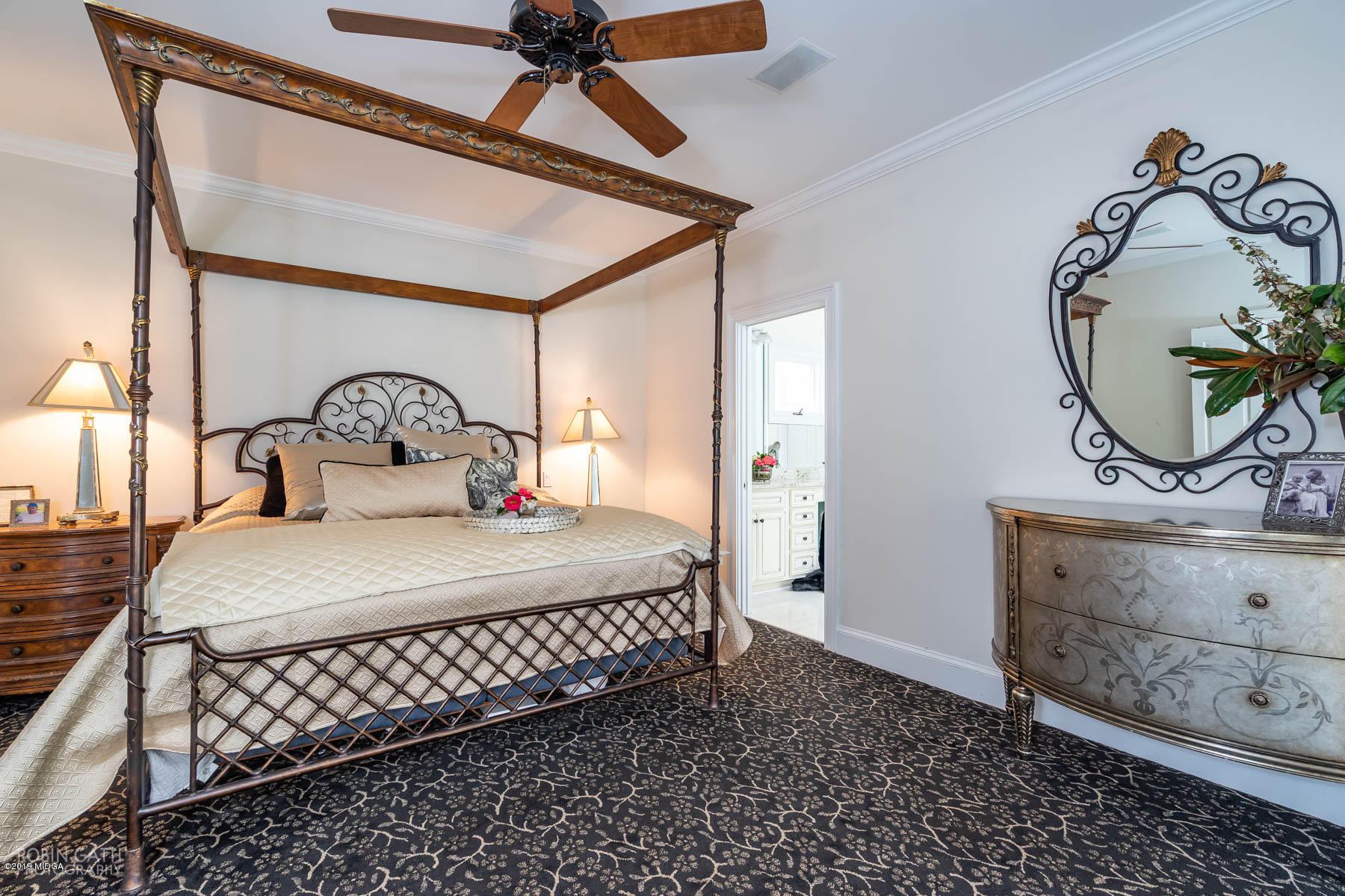 6150 Old Forsyth Road Macon, GA 31210 - Photo 44 of 50 a bedroom with a bed a mirror on the dresser and a chandelier