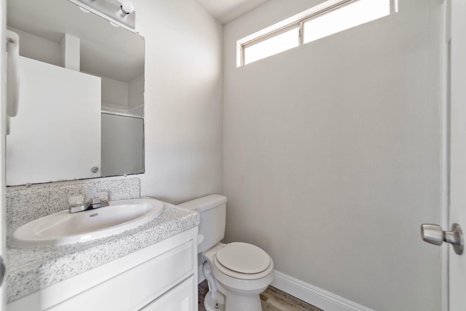 25612 Walden Avenue Madera, CA 93638 - Photo 23 of 33 a bathroom with a granite countertop sink toilet and a mirror