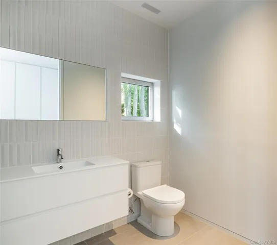 a bathroom with a sink a toilet and mirror