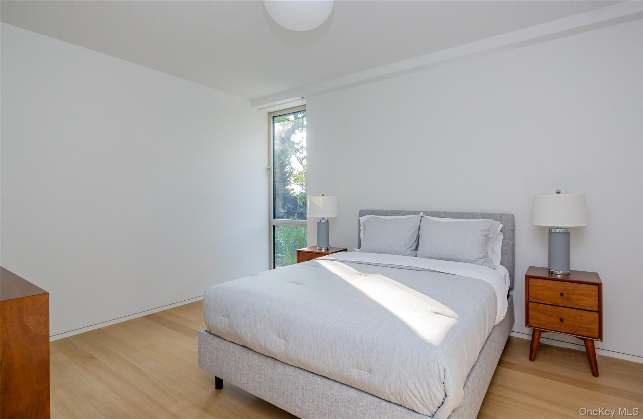 47 L South Ferry Road Shelter Island, NY 11964 - Photo 20 of 38 a bedroom with a bed and a night stand