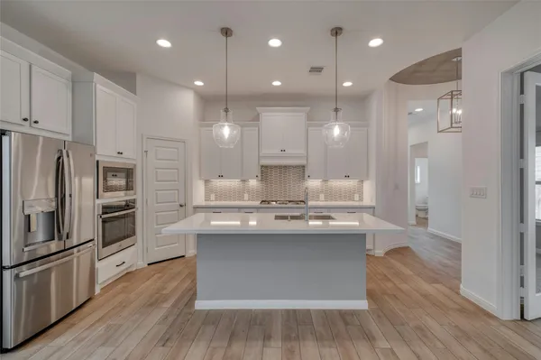 a kitchen with kitchen island a sink stainless steel appliances and cabinets