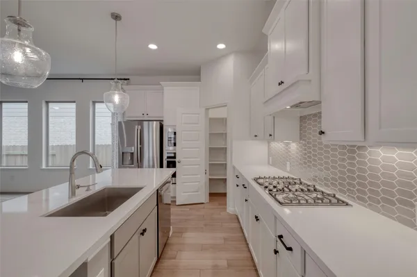 a large kitchen with a large stove a sink and a refrigerator