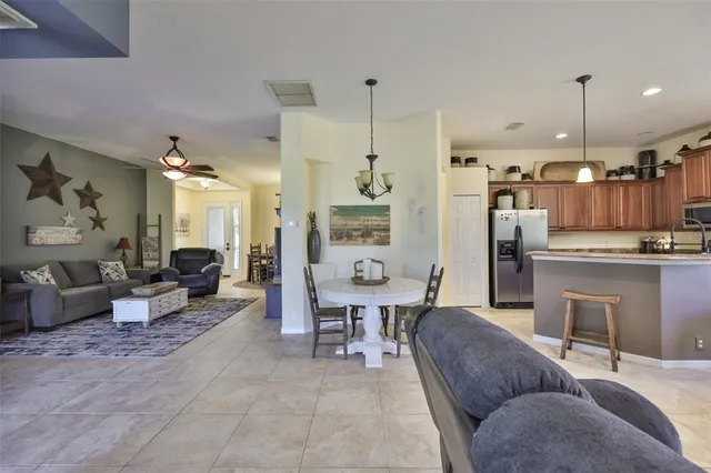 a living room with furniture kitchen view and a chandelier