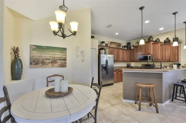 a kitchen with stainless steel appliances kitchen island granite countertop a table chairs and a wooden floor