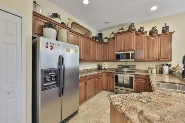 a kitchen with stainless steel appliances granite countertop a refrigerator sink and cabinets