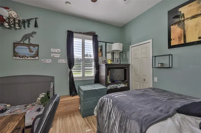 a bedroom with a bed and wooden floor