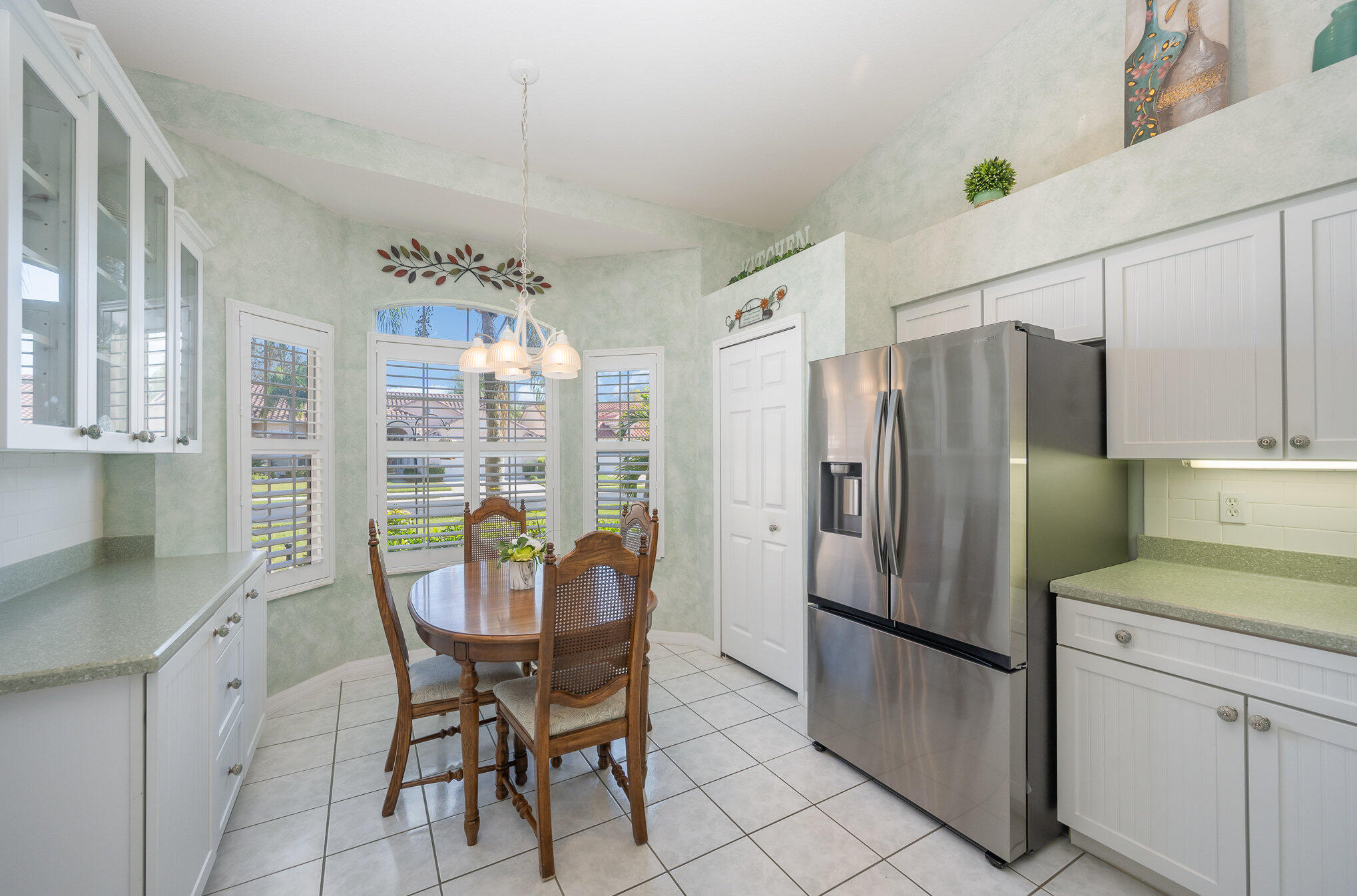 391 Shell Cove Drive Melbourne, FL 32940 - Photo 14 of 37 a kitchen with refrigerator cabinets dining table and chairs