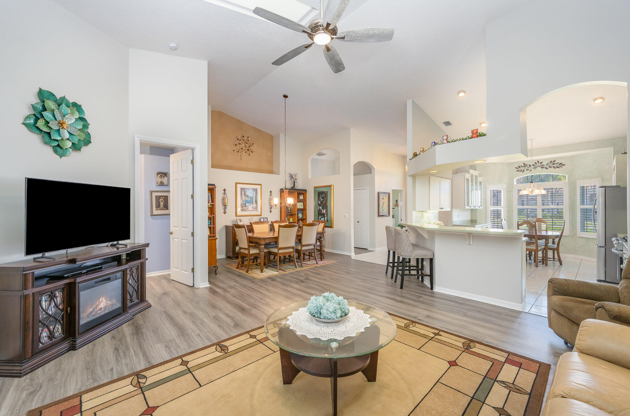 391 Shell Cove Drive Melbourne, FL 32940 - Photo 9 of 37 a living room with furniture a flat screen tv and kitchen view