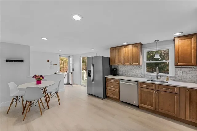 a kitchen with stainless steel appliances a dining table chairs and refrigerator