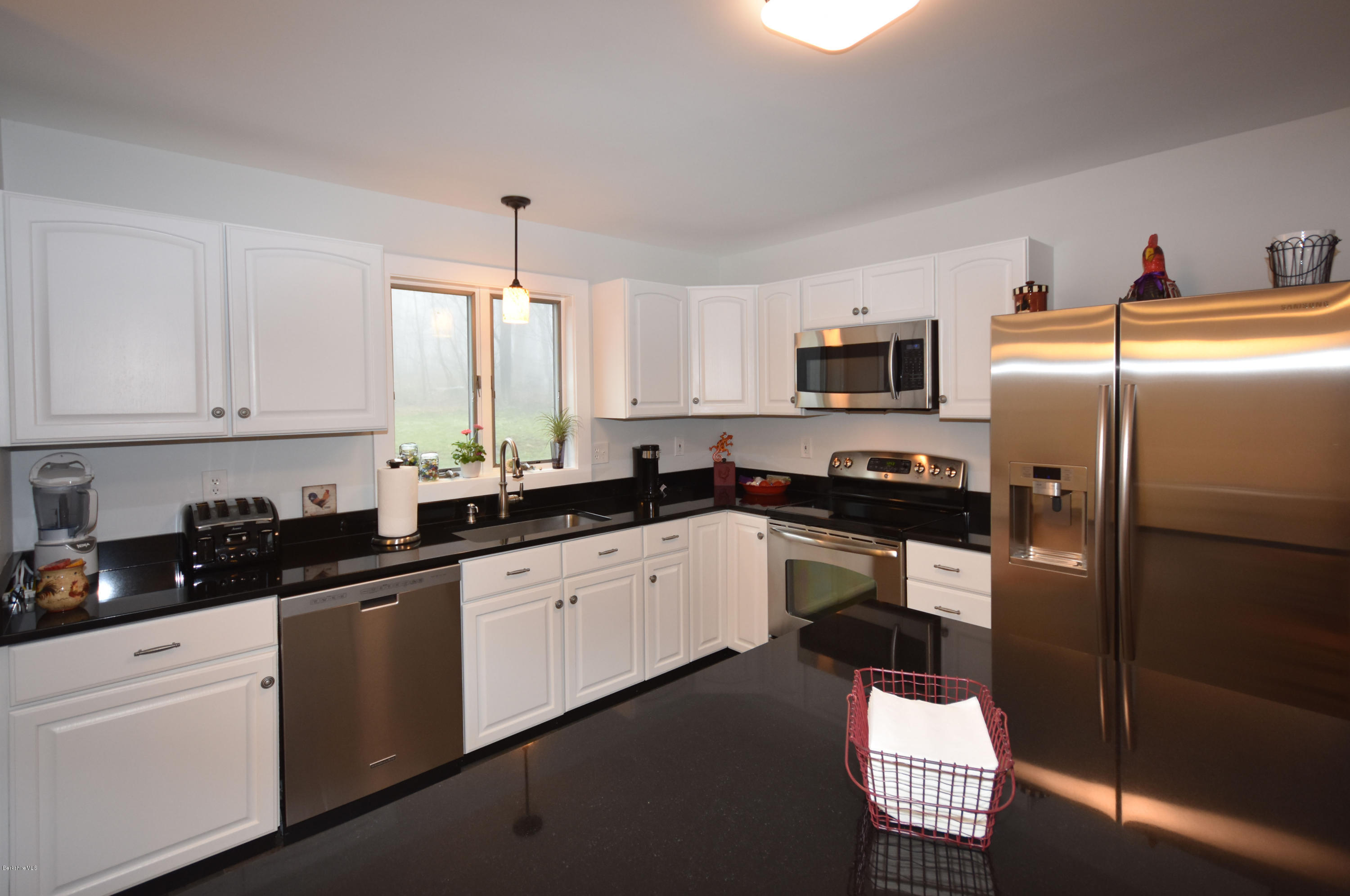 1246 Jacobs Ladder Road Becket, MA 01223 - Photo 14 of 54 a kitchen with granite countertop a refrigerator sink and white cabinets