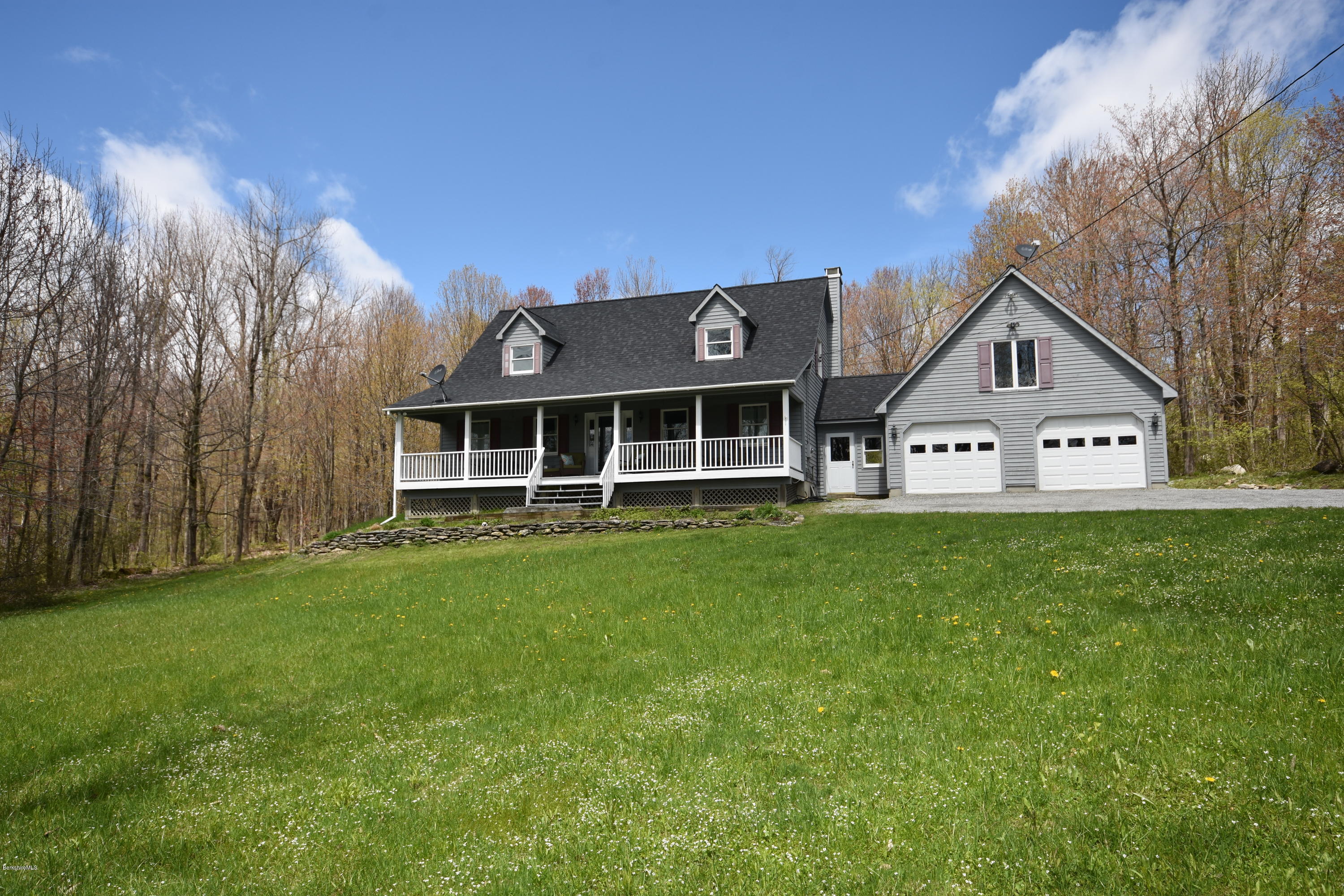 1246 Jacobs Ladder Road Becket, MA 01223 - Photo 4 of 54 a front view of a house with a garden and porch